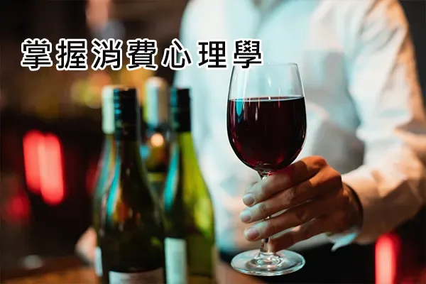 A server at a bar holding a glass of red wine beside several wine bottles, with Chinese text reading "Master consumer psychology"